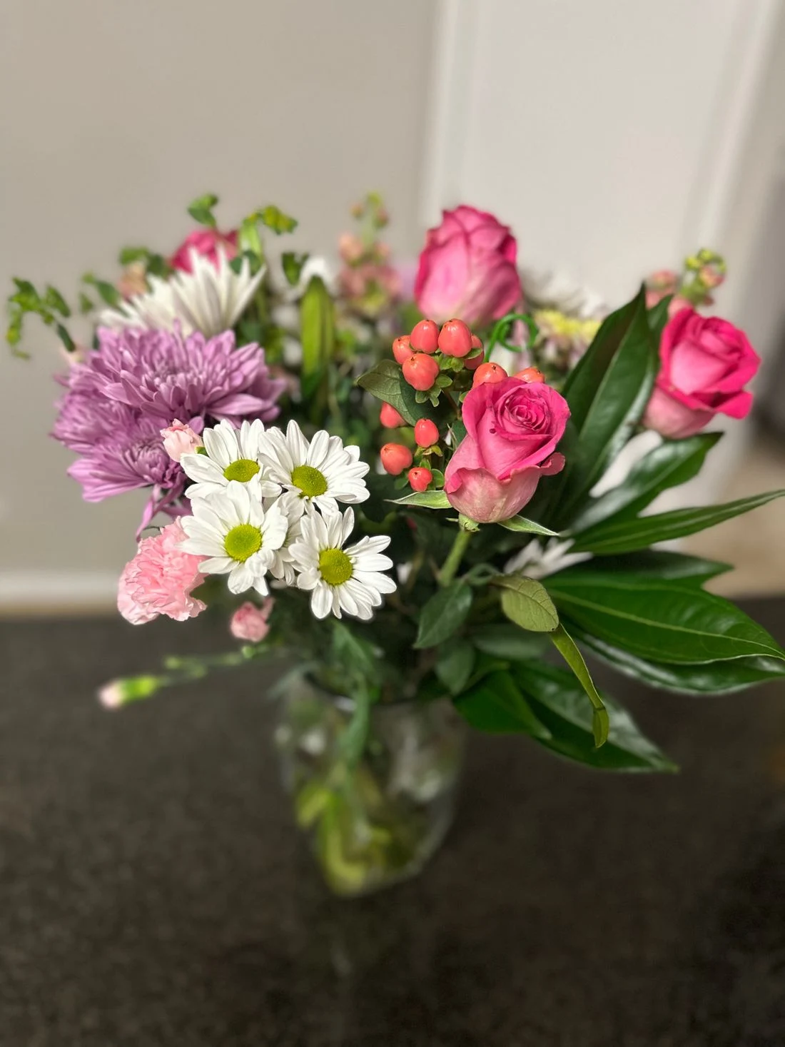 Pink roses, white daisies and purple chrysanthemums gathered in a mixed bouquet